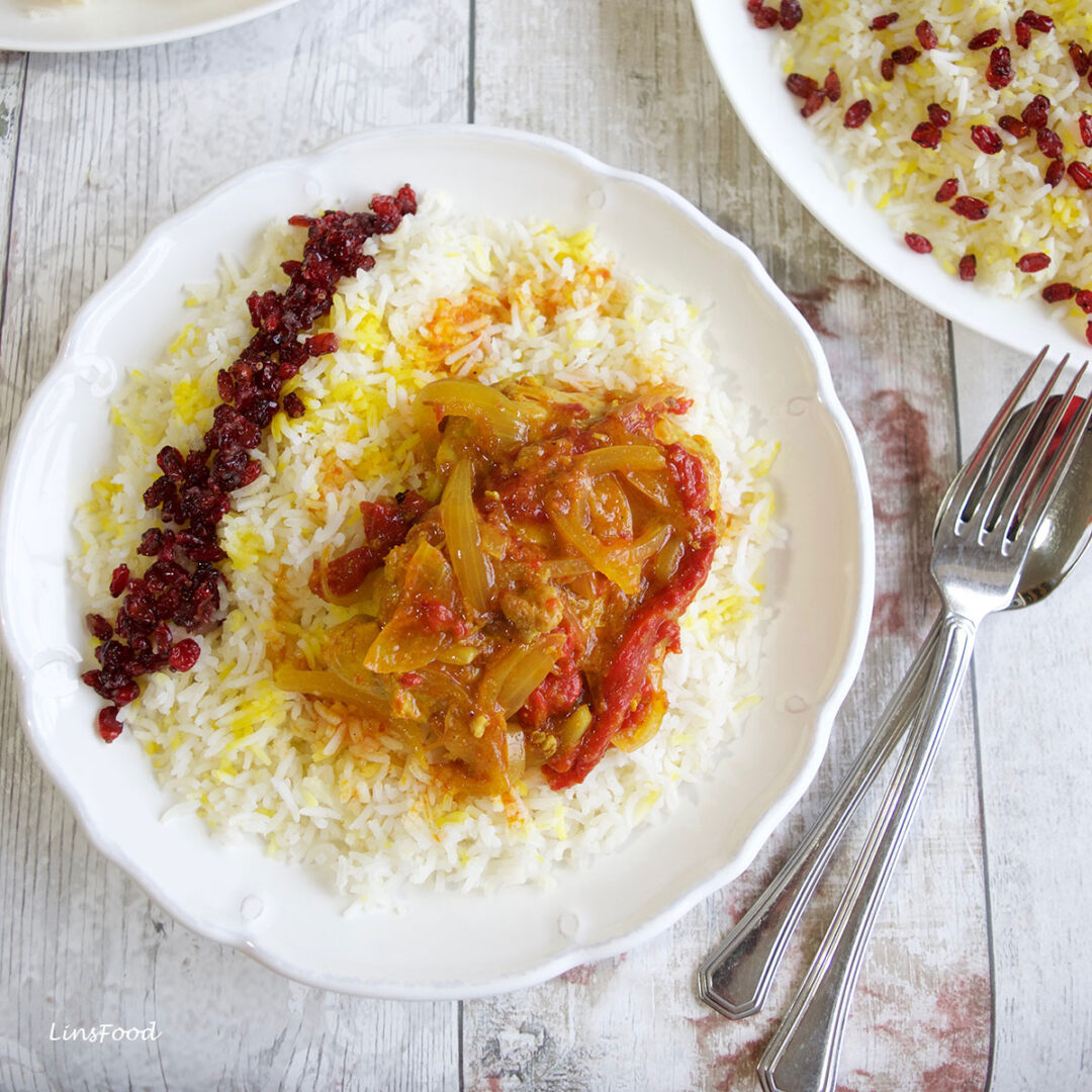 persian rice decorated with barberies and chicken stew
