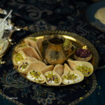 qatayef asafiri filled with ashta on a gold tray with small gold jug